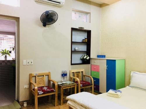 
a room with a bed, desk, chair and a clock at Homestay A1 in Diện Biên Phủ
