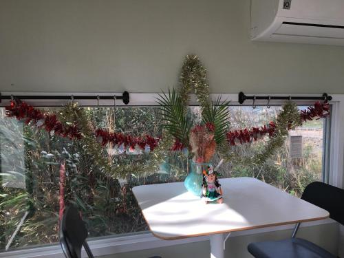 a table with christmas trees in a room with a window at Poema Stay Pension in Jeju