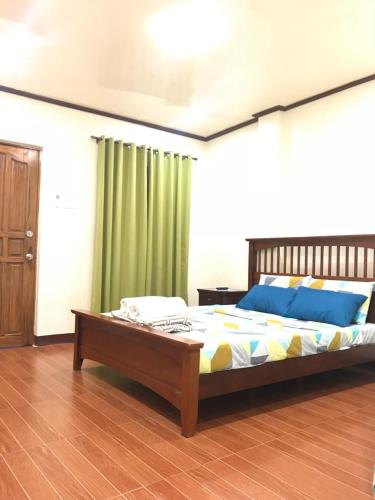 a bedroom with a bed and a green curtain at Hadassah’s Place in Olango Island