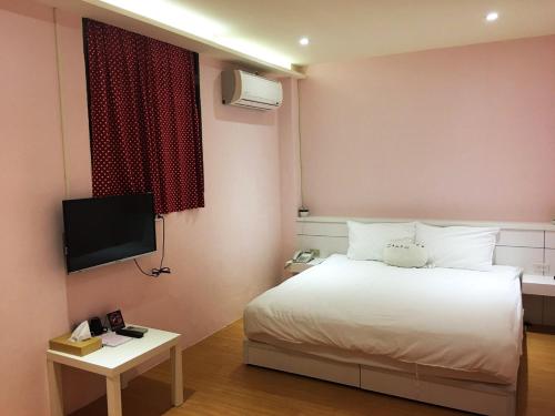 una camera con letto bianco e TV di 3 Feet Cat a Nangan