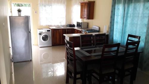 a kitchen with a table and chairs and a refrigerator at Wilks Villa in Knowles
