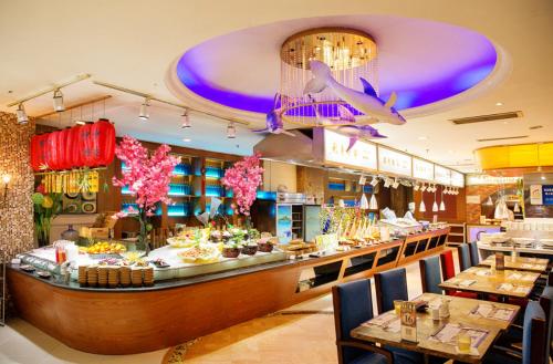 a restaurant with a buffet line with tables and chairs at Qingdao Blue Horizon Hotel - Laoshan in Qingdao