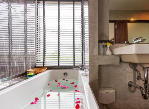 a bathroom with a bath tub with flowers on it at NAP KRABI HOTEL - SHA Extra Plus in Krabi town