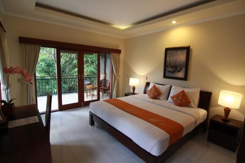 - une chambre avec un grand lit et un balcon dans l'établissement Ketut Kasta Guest House, à Ubud