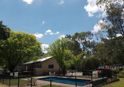 a swimming pool in a park with a building and trees at Euroa Caravan Park in Euroa