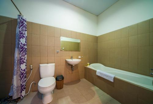 Un baño con inodoro, lavabo y bañera. en Clover Villa Sanur, en Sanur