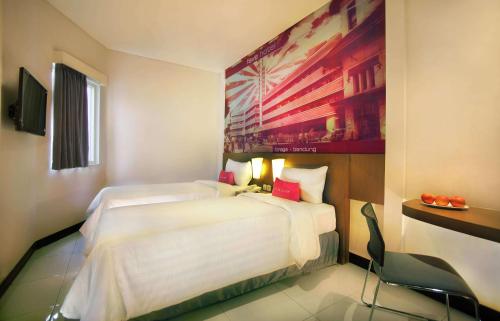 a hotel room with two beds and a painting on the wall at favehotel Braga in Bandung