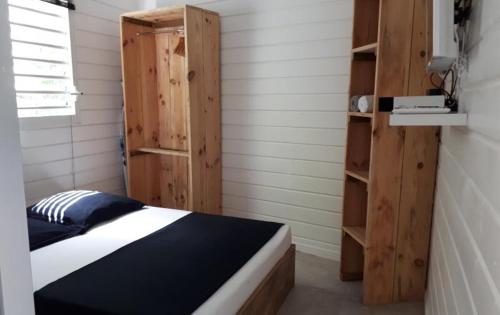 1 dormitorio con cama y estante para libros en ChEZ MAYAH, en Le Gosier