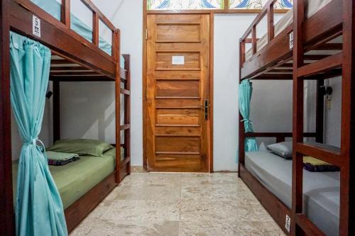 Cette chambre comprend 2 lits superposés et une porte. dans l'établissement Rumah Panjaitan, à Yogyakarta