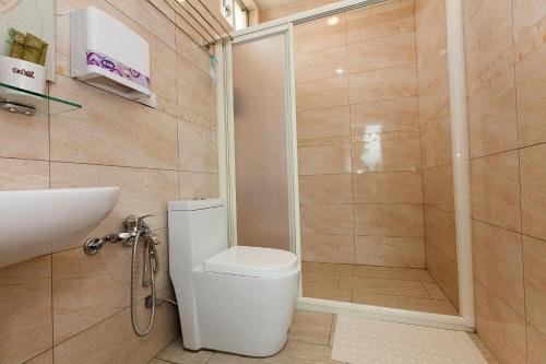 a bathroom with a shower and a toilet and a sink at Yuan Qiwu Homestay in Pinghe