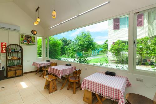 a restaurant with two tables and a large window at Yuan Qiwu Homestay in Pinghe