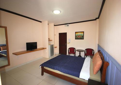 a bedroom with a bed and a television in it at Matini Amata in Ban Hua Phai