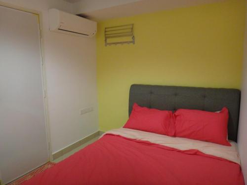 a bed with red pillows in a room at Famosa 2 Stay in Melaka
