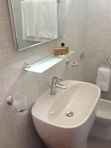 a bathroom with a white sink and a mirror at Hotel Mediterraneo in Roccella Ionica