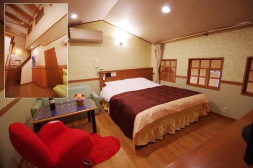 a hotel room with a bed and a red chair at Alohain Yonago in Yonago