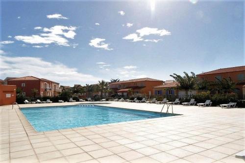 une grande piscine dans une cour avec des bâtiments dans l'établissement Villa 8 De Oranje Tulp, au Barcarès