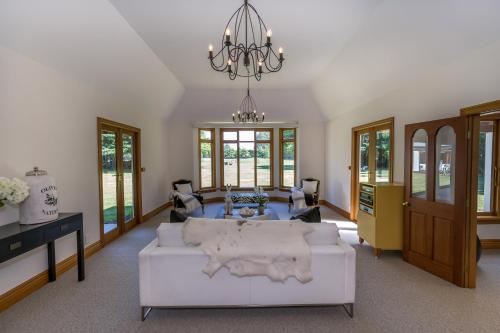 a living room with a white couch and a chandelier at BOND ESTATE LUXURY ACCOMMODATION in Christchurch