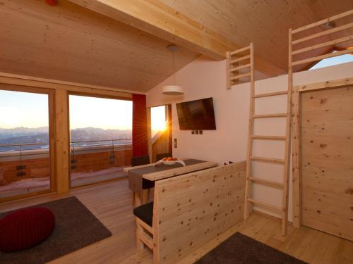 a bedroom with a bunk bed and a desk and a ladder at Alpinhotel Pacheiner in Treffen