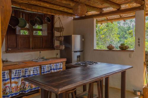 a kitchen with a wooden table and a counter top at Casa Upa ,casa con piscina espectacular, Barichara in Barichara