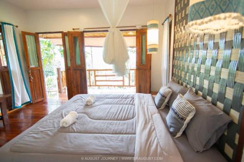 ein Schlafzimmer mit einem großen Bett mit zwei Teddybären darauf in der Unterkunft Ban Suan Nai Fun Homestay in Pua