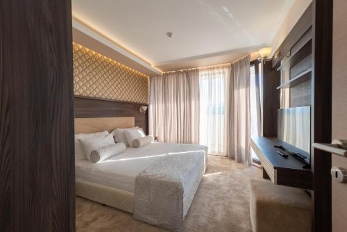 a hotel room with a bed and a television at Mantar Spa Hotel in Marikostinovo