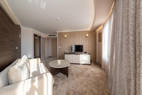 a living room with a couch and a table at Mantar Spa Hotel in Marikostinovo