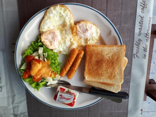 a plate of food with a egg and toast and vegetables at We Love Kata in Kata Beach