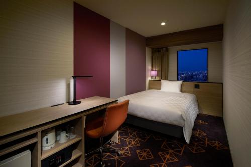 a hotel room with a bed and a desk and a window at Sunshine City Prince Hotel Ikebukuro Tokyo in Tokyo