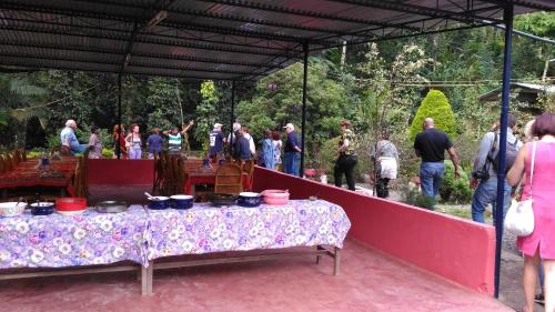 een groep mensen die rond een tafel staan met potten en pannen bij Philip Mary Farm Stay in Thekkady