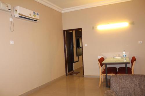 a room with a table and chairs and a light at Hotel Pooja International in Dāvangere