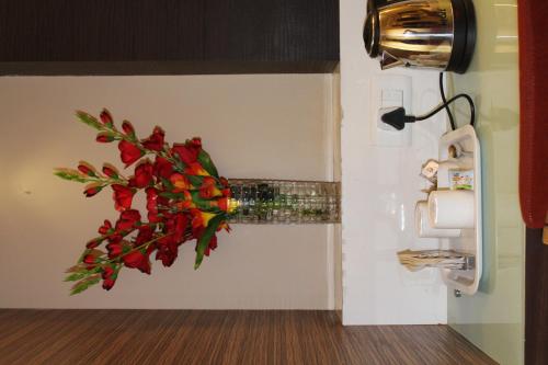 a bunch of red flowers on the wall of a bathroom at Hotel Pooja International in Dāvangere