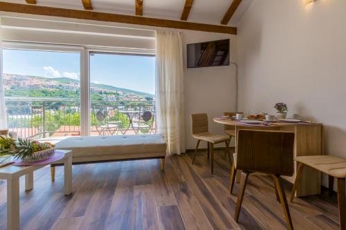 a room with a bed and a table and a large window at Gold Sea in Crikvenica