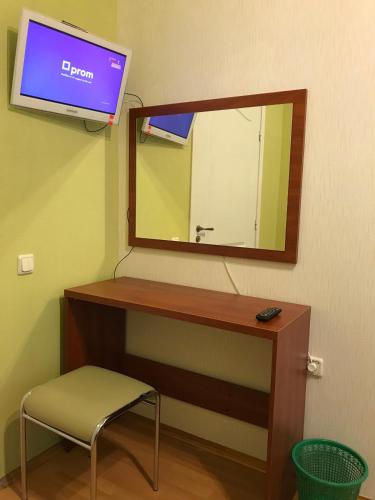 a bathroom with a mirror and a chair and a tv at Хостел и Апартаменты Друзья in Dnipro