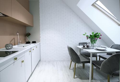 a kitchen with a table and a white brick wall at Absyntapart - Bulwar Staromiejski in Wrocław