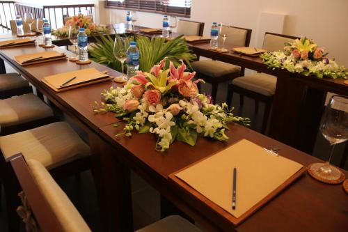 a long table with a bouquet of flowers on it at Hoi An Eco Lodge & Spa in Hoi An