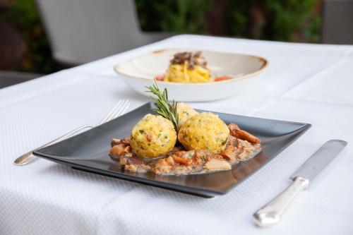 a plate of food with potatoes on a table at Hotel Bemelmans-Post in Collalbo
