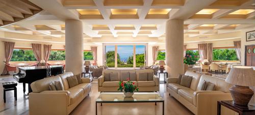 a large living room with couches and a piano at Tombolo Talasso Resort in Marina di Castagneto Carducci