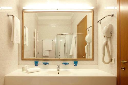 baño con lavabo y espejo grande en Residence Liberty, en Trieste