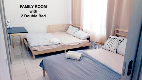 two beds in a small room with a double bed at HomezStay Soho Timesquare Miri in Miri