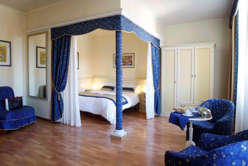 a bedroom with a canopy bed with blue curtains at Residence Liberty in Trieste