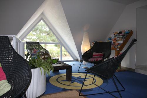 a living room with three chairs and a window at L'Hippocampe in Plouharnel