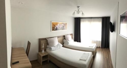 a hotel room with two beds and a window at Hotel Prezydencka in Legionowo
