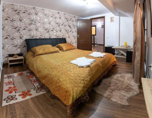 a bedroom with a bed with two towels on it at Casa Lazar in Buşteni