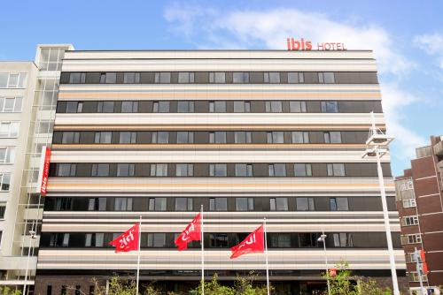a building with red flags in front of it at ibis Leiden Centre in Leiden