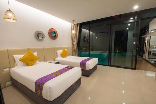 a bedroom with two beds and a swimming pool at Good Night Pool Villa Phuket - SHA Plus in Phuket Town