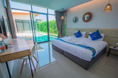 ein Schlafzimmer mit einem Bett, einem Tisch und einem Pool in der Unterkunft Good Night Pool Villa Phuket - SHA Plus in Phuket