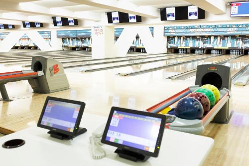 a bowling alley with a table with a laptop and a monitor at Shinagawa Prince Hotel East Tower in Tokyo