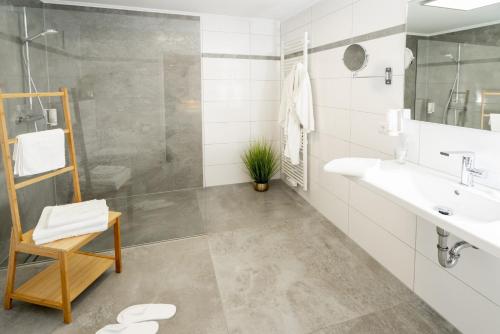 a bathroom with a sink and a shower at Hotel Tiek Superior in Meppen