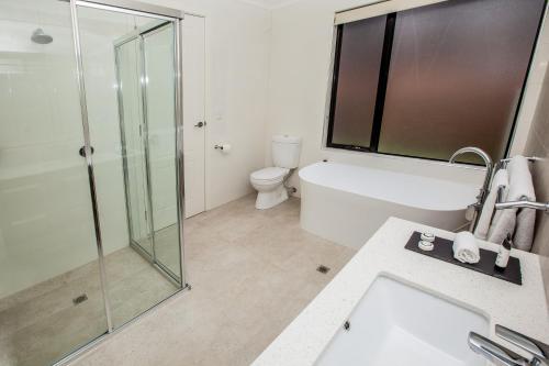 a bathroom with a glass shower and a toilet at Neagles Retreat Villas in Clare