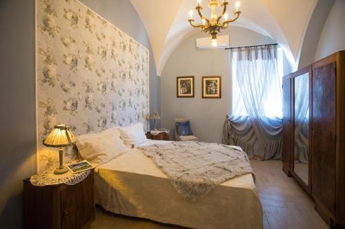 a bedroom with a bed and a lamp and a window at C'ERA UNA VOLTA - casa vacanza Etna-Sicilia-mare in Linguaglossa